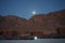 The moon shines over the mountains in Dahab, South Sinai Governorate, Egypt