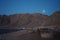 The moon shines over the mountains in Dahab, South Sinai Governorate, Egypt