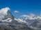 Moon shining over the famous matterhorn with clouds and blue sky