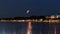 moon on starry sky at night blue city light  reflection on water wave  in port   Tallinn  in Estonia