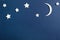 Moon and stars on blue background top view. Night sky objects with shadow close up. Decorative backdrop. Childish applique,