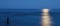 Moonlight on calm blue sea with wooden pole