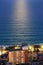 Moonlight reflection on dark-blue water surface at seaside resort