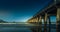 The moonlit Historic wharf at Tolaga Bay in the dark with gentle surf waves rolling in