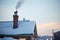 moonlit snowy rooftop with chimney and rising smoke silhouette