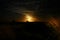 Moonrise on the coast with starts and scattered clouds