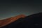 Moonrise over the mountain peak with bright clouds in the night in autumn season