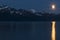 Moonrise over mountains with full moon reflection