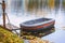 Moored boat in the autumn pond. Autumn scene, fallen yellow leaves on the shore, picturesque colors of nature, natural