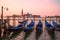 Moored gondolas on the background of the Cathedral of San Giorgio Maggiore on sunrise. Venice