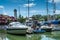 Moored sailboats against the blue sky with clouds in the afternoon. Lighthouse surrounded by palm trees. House in