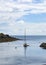 Moored sailing boat yacht with rocks to side