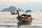 Moored thai traditional long-tail boat in the sea water near the shore in