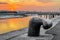 Mooring bollard, iron cleat with colorful sunset