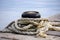 Mooring bollards with old, damaged rope tide around it on the marine dock