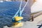 Mooring rope tied to the bollard at the pier.Nautical mooring rope. Shipping objects concept. Sailing ropes. Yellow marina bollard