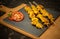 Moorish skewers on black stone and wooden cutting board with tomato slices