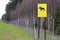 Moose crossing sign. Wildlife migration sign and forest fence. Beware of moose walking across the road