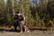 Moose hunter sitting on a road drinking tea