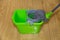 MOP with bucket for rinsing and wringing water green on a background of brown laminate, care household