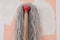 the mop with long cotton gray threads on wooden the stick on the background of the wall pink color with white spots during repair