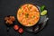 Moqueca with Fish and Shrimps in black bowl on dark slate table top. Brazilian sea food curry dish