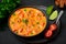 Moqueca with Fish and Shrimps in black bowl on dark slate table top. Brazilian sea food curry dish