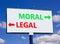 Moral or legal symbol. Concept word Moral or Legal on beautiful billboard with two arrows. Beautiful blue sky with clouds