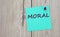 MORAL - word written on a green sheet for notes, which is pinned to a light wooden board
