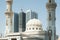 Mordern arabic mosque and high-rise buildings on the background