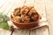 Morel mushrooms in a brown ceramic bowl on a wooden table.