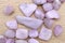 Morganite heap up stones texture on light varnished wood background. Horizontal orientation