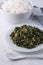 Moringa or drumstick leaves dish, tempered vegetarian dish on a white surface