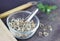 Moringa seed dried in a clear glass cup, background spoon, wooden sheet, flower sack, grass, wooden spoon
