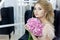 Morning of a beautiful tender sweet bride in a boudoir dress with a bouquet of hydrangea flowers with an evening hairdo and bright