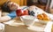 Morning breakfast food on the wooden tray in the hotel bed next to the sleeping person f