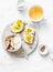 Morning breakfast table inspiration - sandwiches with cream cheese and boiled egg, yogurt with apple and flax seeds, herbal detox