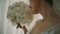The morning of the bride in a white roses holds in her hands a wedding bouquet of roses. Close up. V4