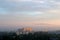 Morning city panorama in foggy haze and gentle rays of the dawn sun