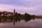 Morning cityscape of medieval Telc. Tower of Church of the Holy Spirit in Telc reflected in the water of the castle lake