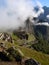 The morning clouds lifting to reveal Machu Picchu and the steep drop away from the terraced plateau, Peruvian Andes, South America