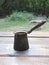 Morning coffee in cezve on wooden table in the tourist camp on fireplace backgroud. Camping, hiking, adventure photo