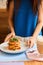 Morning coffee. Closeup of women`s hands with coffee cup in a cafe. Female hands holding cup of latte on a wooden table backgroun