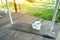 Morning coffee cup on wood swing in green garden space