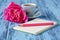 Morning coffee mug, empty notebook, pencil and white peony flowers on blue wooden table