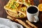 Morning concept with a cup of coffee, breadsticks, fruit pies and oranges on wooden background.