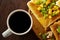 Morning concept with a cup of coffee, breadsticks, fruit pies and oranges on wooden background.