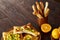 Morning concept with a cup of coffee, breadsticks, fruit pies and oranges on wooden background.