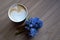 Morning Cup of coffee and a beautiful lowers on light wood background