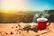 Morning cup of coffee and coffee beans with mountain background at sunrise. Beauty mountain landscapes